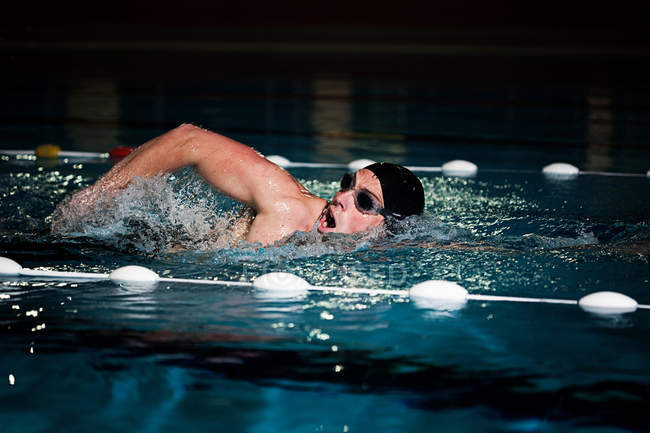 Entrenamiento de hombre deportivo en la piscina - foto de stock