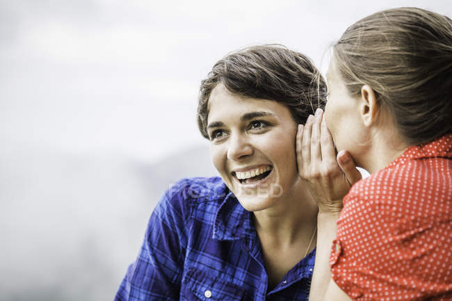 Two female friends sharing secret — Stock Photo
