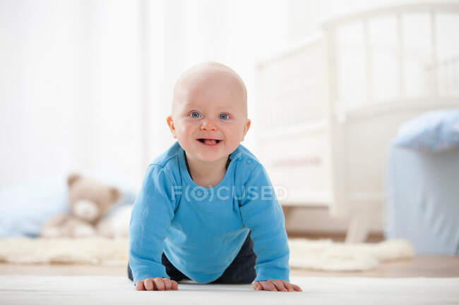 Baby boy crawling on carpet — Stock Photo