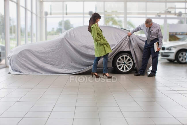 Vendedor de coches mostrando coche para mujer - foto de stock