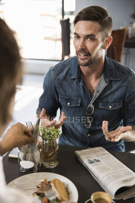 Hombre en el restaurante charlando con un amigo - foto de stock
