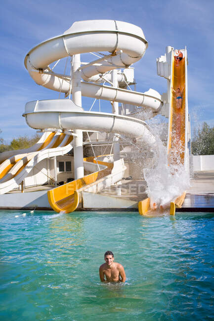 Man smiles in water at giant water slide — Stock Photo