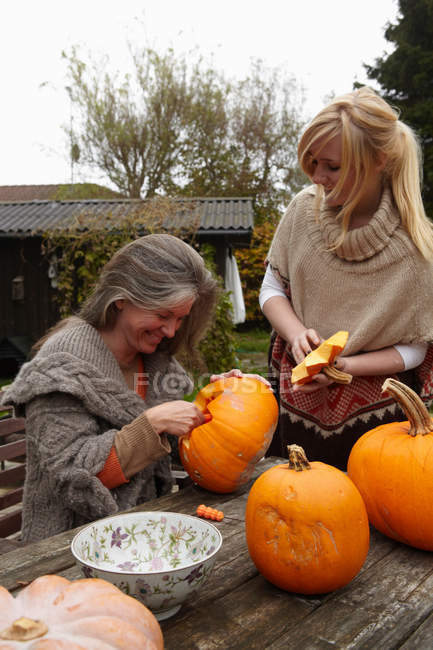 Mãe e filha esculpindo abóboras — Fotografia de Stock