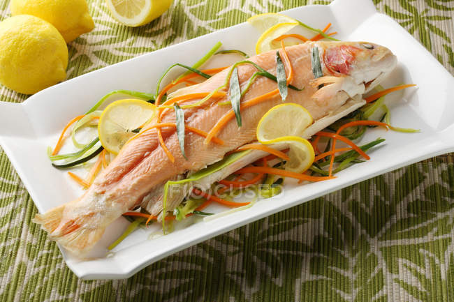 Plan rapproché du plat avec du saumon rôti et des légumes — Photo de stock
