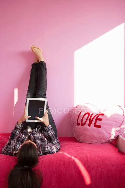 Жінка використовує планшетний комп'ютер на ліжку — стокове фото