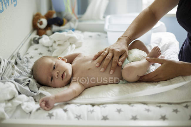 Cropped image of Mothers hand massaging baby son — Stock Photo