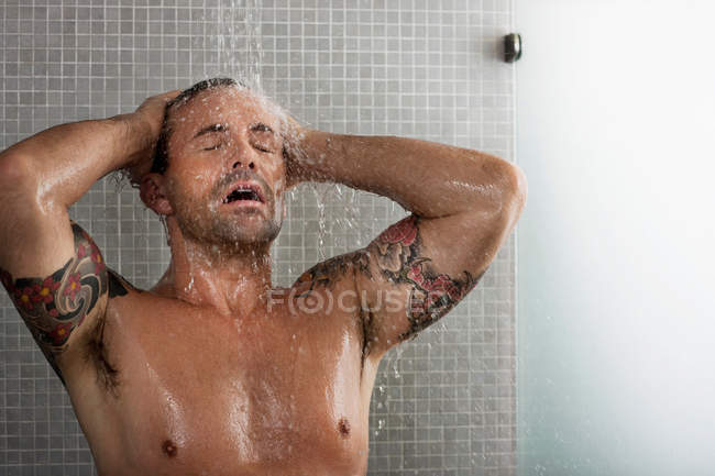 Homme se laver les cheveux sous la douche, mise au point sélective — Photo de stock