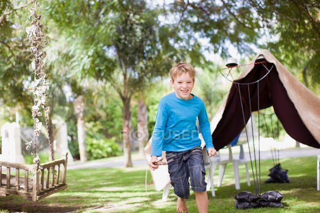 Мальчик играет на заднем дворе — стоковое фото