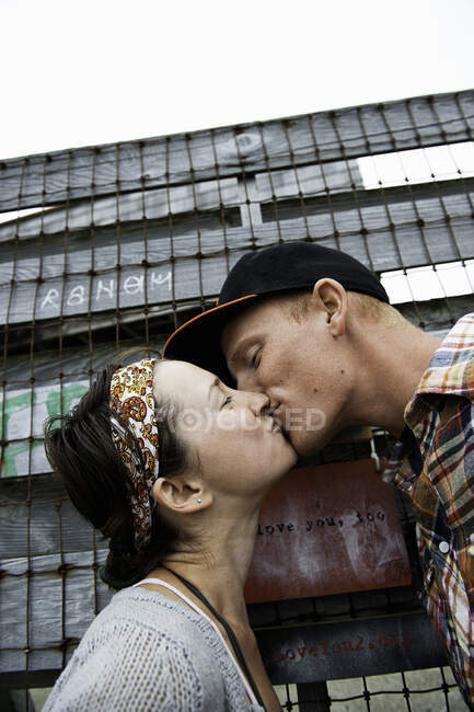 Jeune couple baisers avec les yeux fermés — Photo de stock