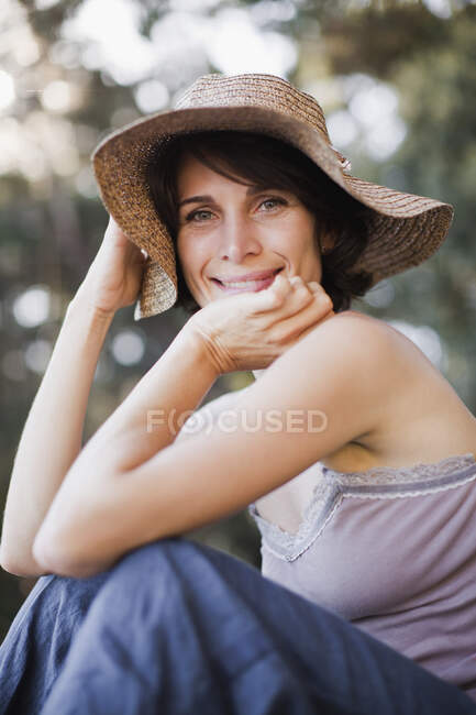 Mulher sorridente usando chapéu de sol — Fotografia de Stock