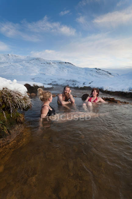 Amigos relajándose en aguas termales glaciares - foto de stock