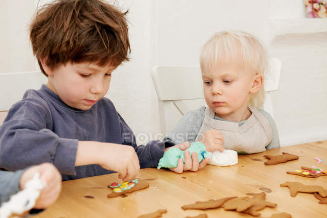 Garçons décorant biscuits au pain d'épice — Photo de stock