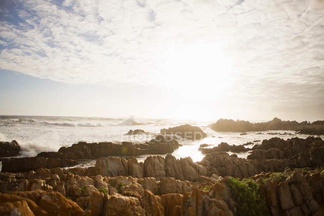 Хвилі розбиваються над камінням на пляжі — стокове фото