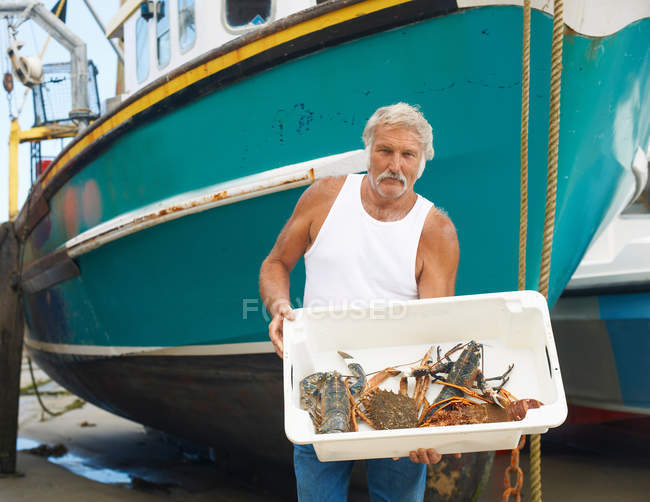 Pescador sosteniendo captura en barco - foto de stock