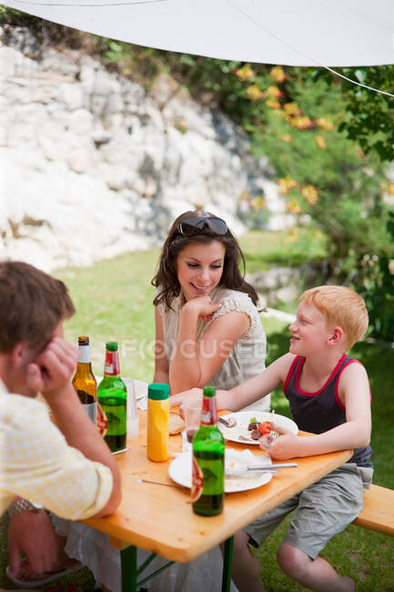Familia hablando en la mesa al aire libre - foto de stock
