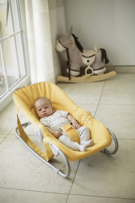Baby boy lying in yellow cradle — Stock Photo