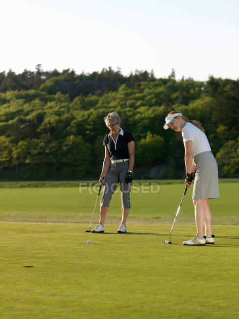 Duas mulheres no golfe verde — Fotografia de Stock