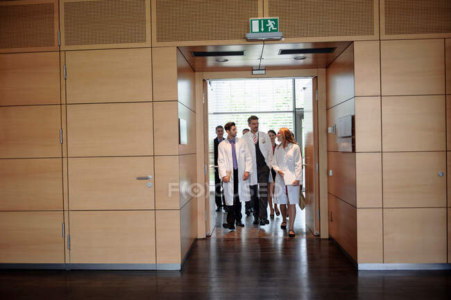 Médicos caminando en el pasillo de la oficina - foto de stock