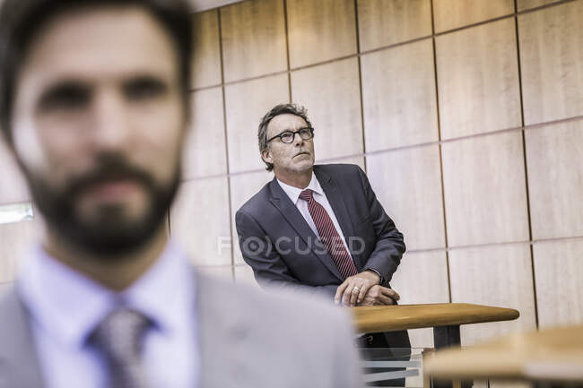 Uomo d'affari anziano in attesa sul balcone ufficio — Foto stock