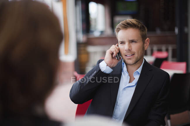 Geschäftsmann am Handy beim Mittagessen — Stockfoto