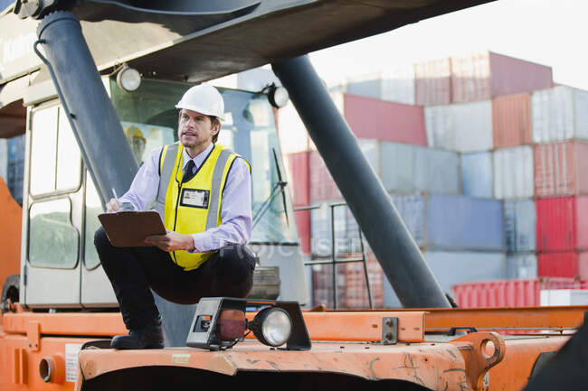 Worker standing on machinery on site — Stock Photo