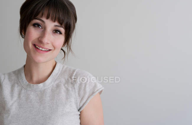Primo piano di donna sorridente sullo sfondo grigio — Foto stock