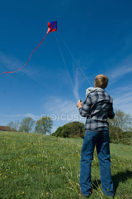 Boy flying a kite in field — Stock Photo