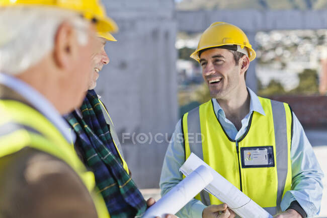 Empresário e trabalhadores conversando no local — Fotografia de Stock