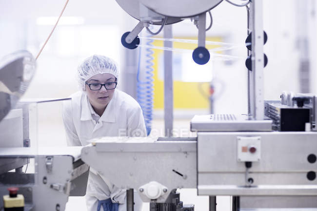 Працівник заводу експлуатує обладнання для виробництва харчових продуктів — стокове фото
