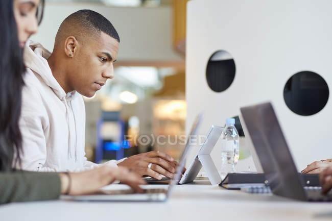 Young University students using laptops and digital tablet, working together — Stock Photo