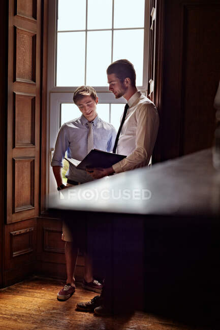 Businessmen talking by window — Stock Photo
