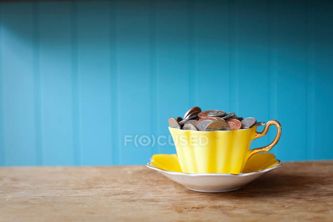 Teacup full of money — Stock Photo