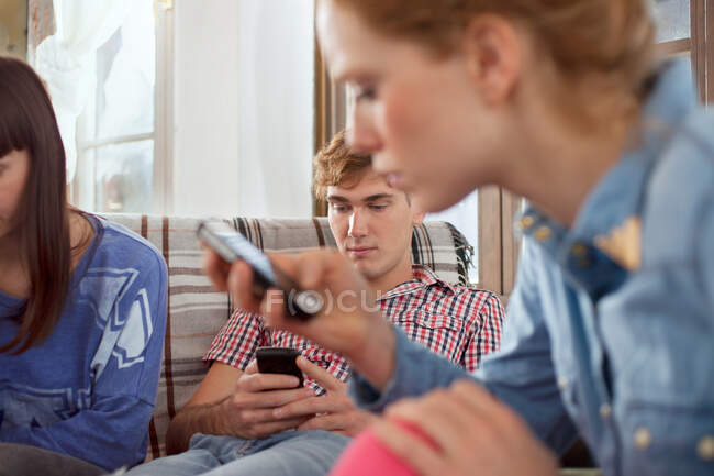 Grupo de amigos usando teléfonos inteligentes - foto de stock