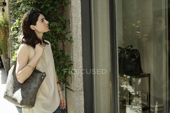 Femme acheteuse regardant la vitrine, Milan, Italie — Photo de stock