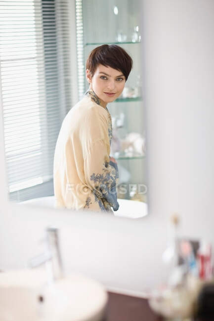 Жінка в халаті сидить у ванній — стокове фото