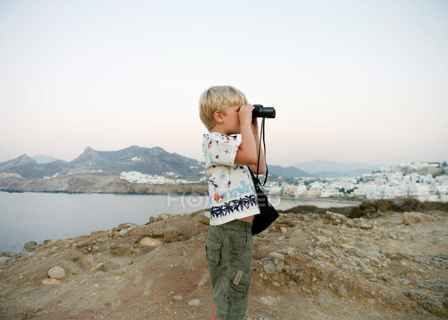 Young boy using binoculars in Greece island — Stock Photo