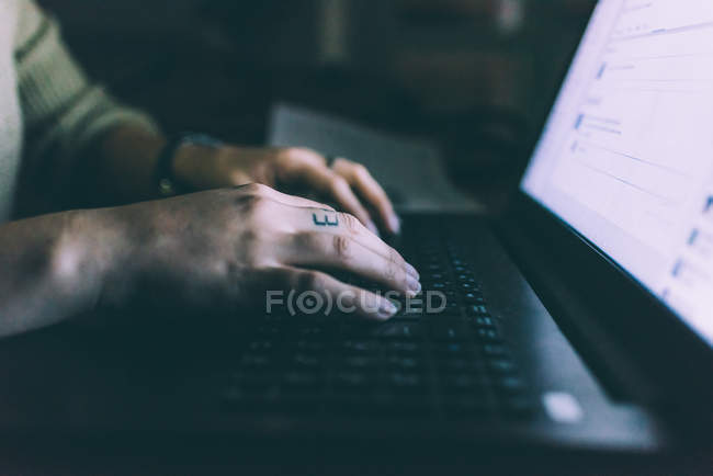 Рука молодої жінки, що друкує на ноутбуці — стокове фото