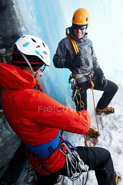 Escaladores de hielo en cueva de hielo preparando equipos de escalada - foto de stock