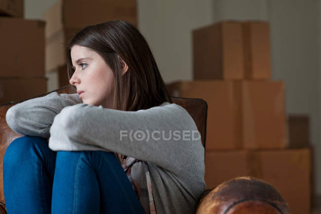Teenage girl in armchair in new home — Stock Photo