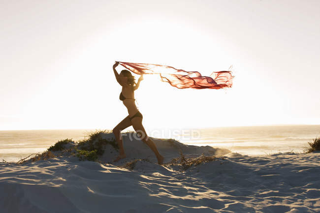Donna che corre con il pareo sulla spiaggia — Foto stock