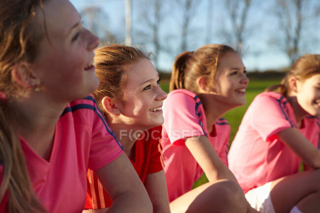 Футбольная команда улыбается вместе в поле — стоковое фото