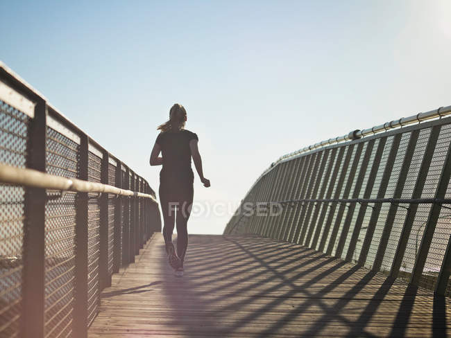 Woman running on skybridge, selective focus — Stock Photo