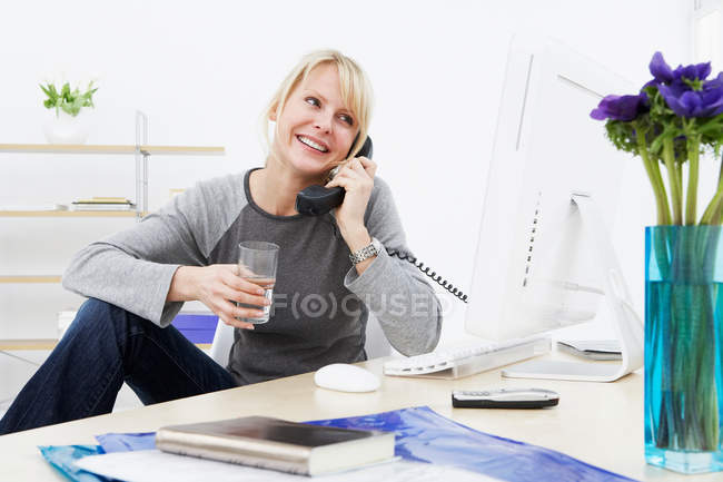 Бізнес-леді розмовляють по телефону на роботі — стокове фото