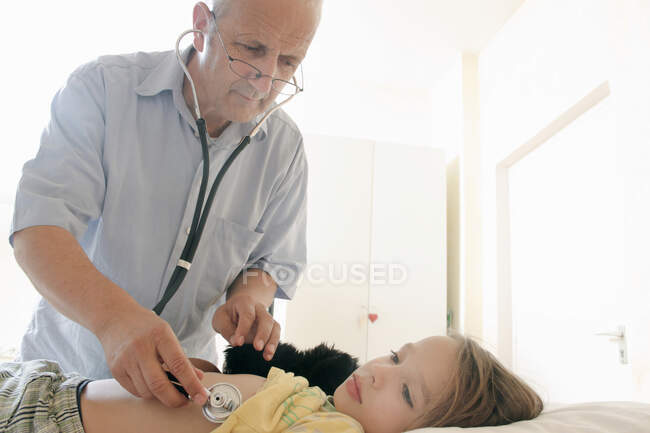 Doctor examining girl with stethoscope — Stock Photo