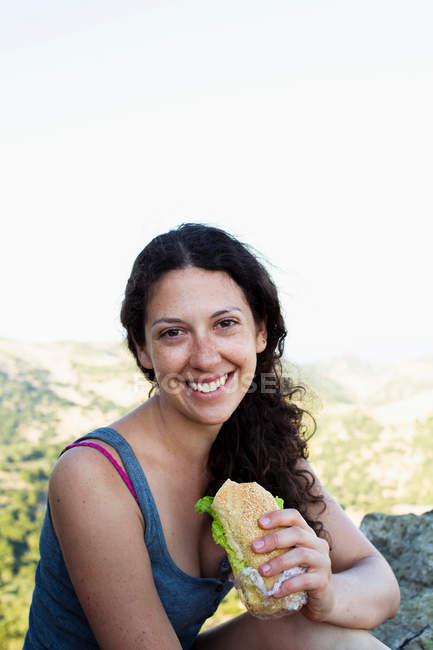 Caminhante comer sanduíche na colina, foco em primeiro plano — Fotografia de Stock