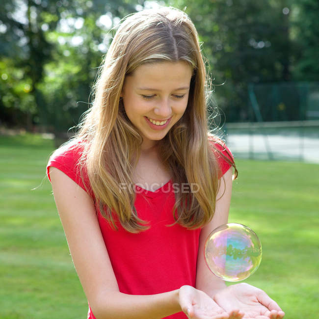 Chica jugando con burbuja de jabón - foto de stock