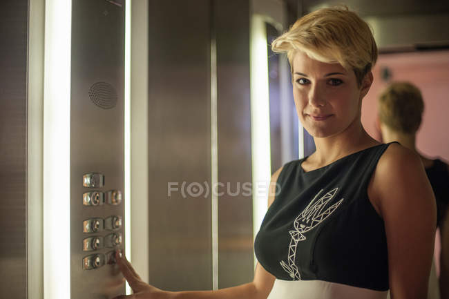 Femme d'affaires appuyant sur le bouton ascenseur — Photo de stock