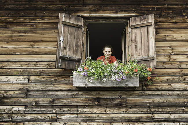 Portrait of woman at chalet window — Stock Photo