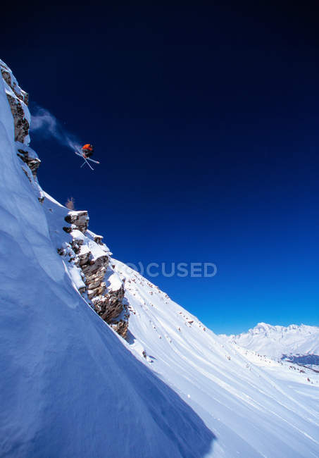 Skier making jump on mountainside — Stock Photo