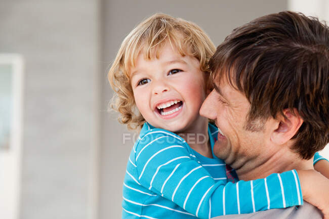 Hijo y padre abrazándose - foto de stock